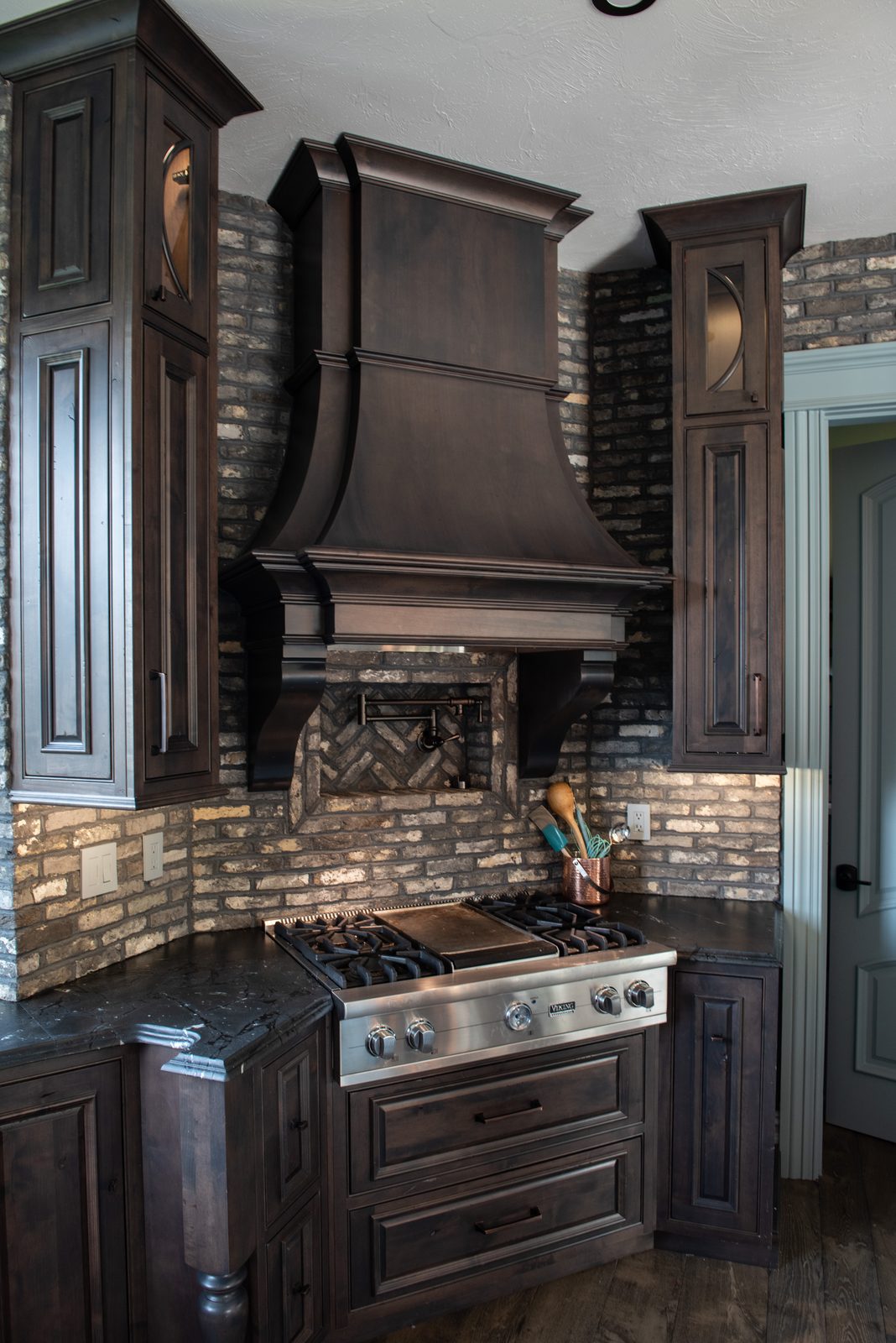 Custom wood hood over brick backsplash