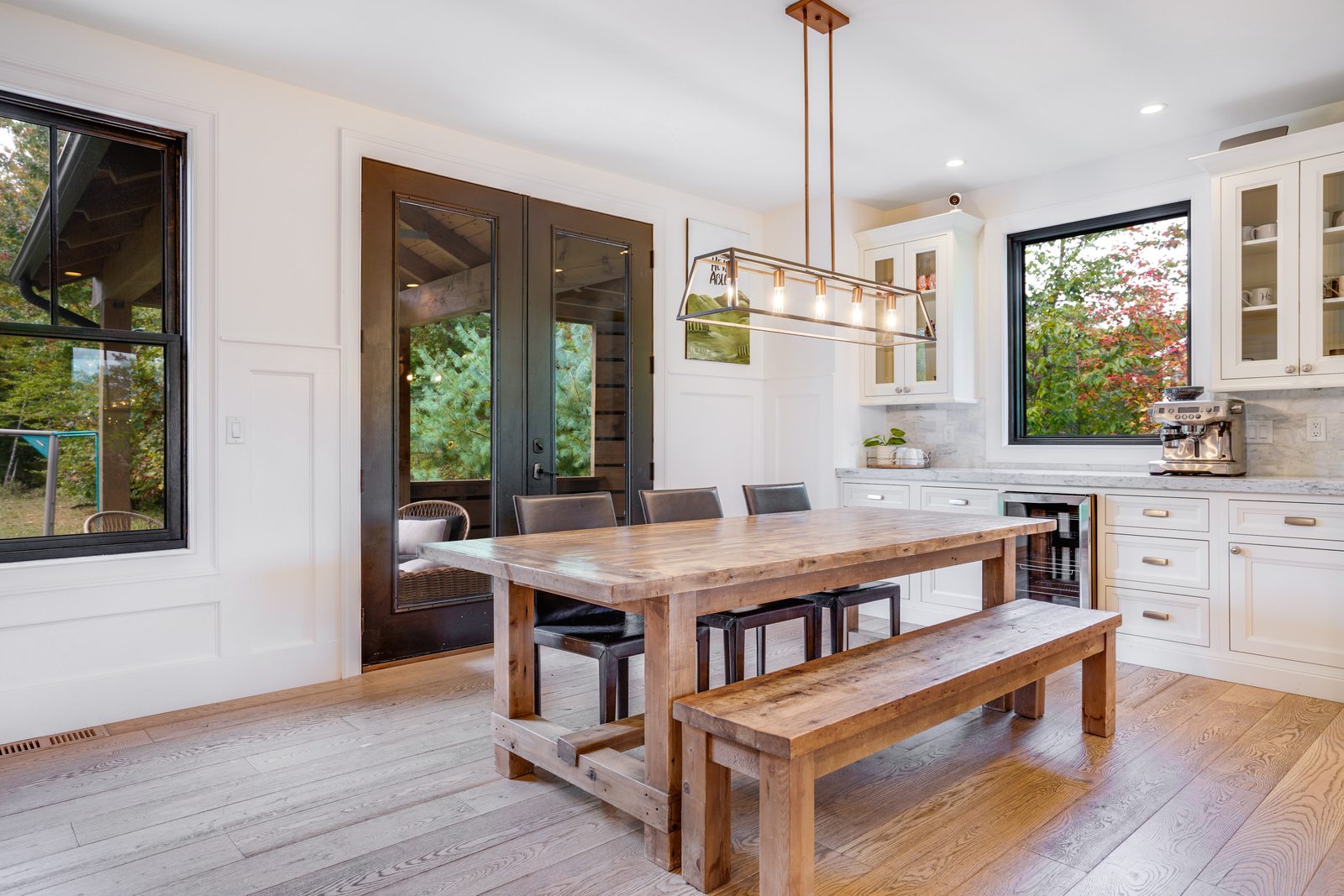 Dining nook with bench seating and bar cabinets beyond