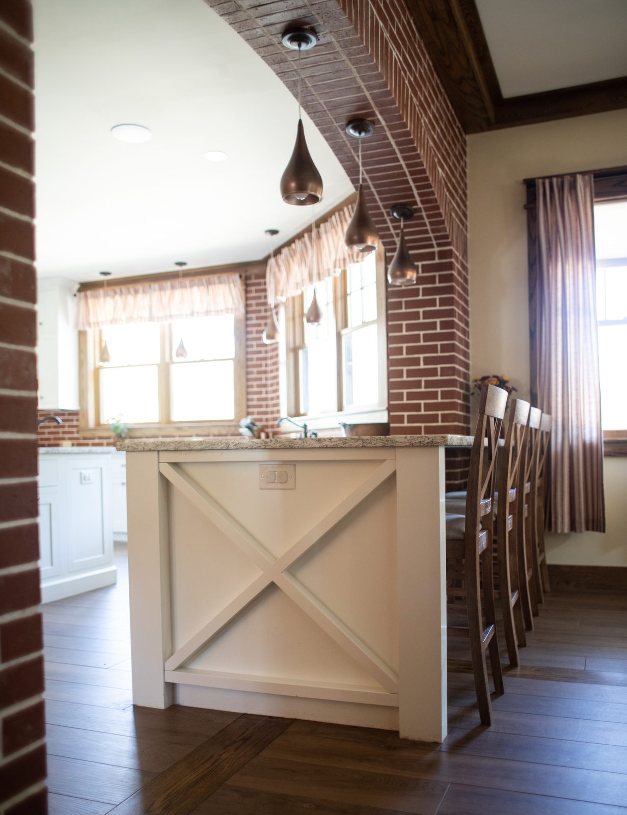 Brick archway into the kitchen with X-panel island
