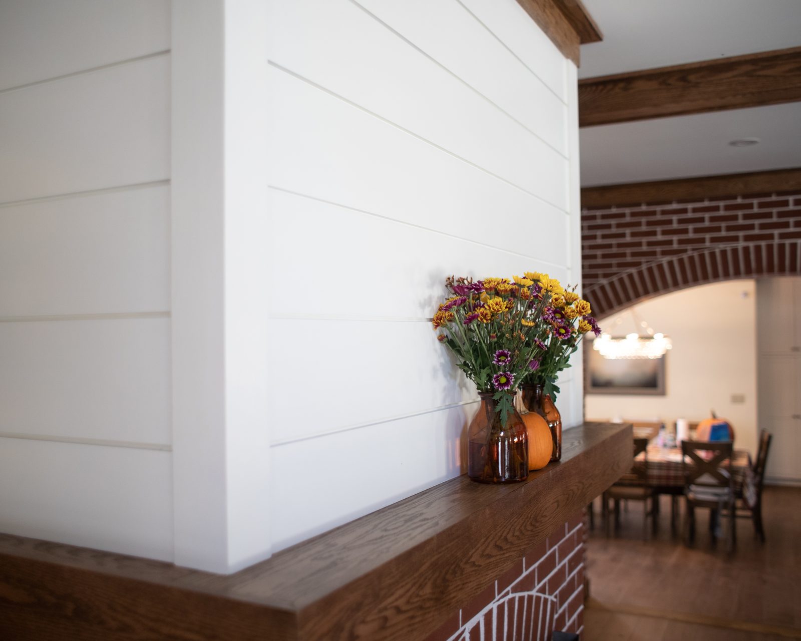 Shiplap wall and dining room through the brick arch