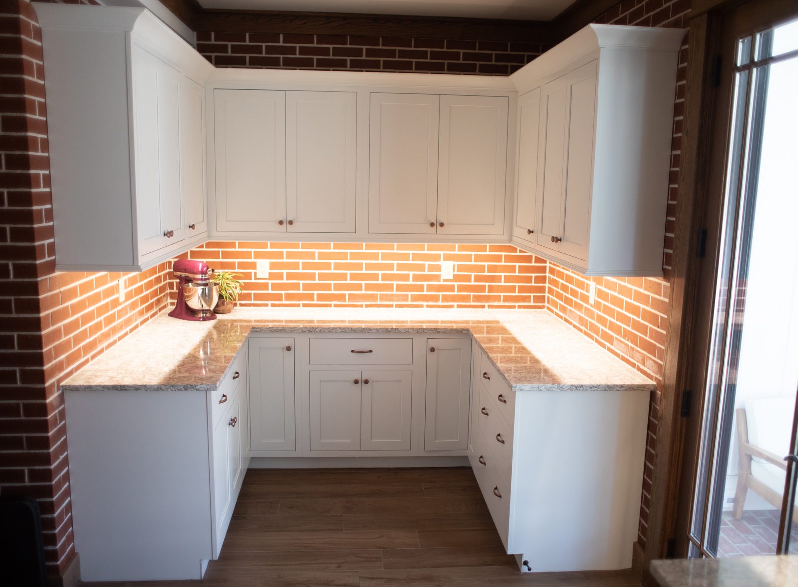 Butler's pantry with brick backsplash and under-cabinet lighting