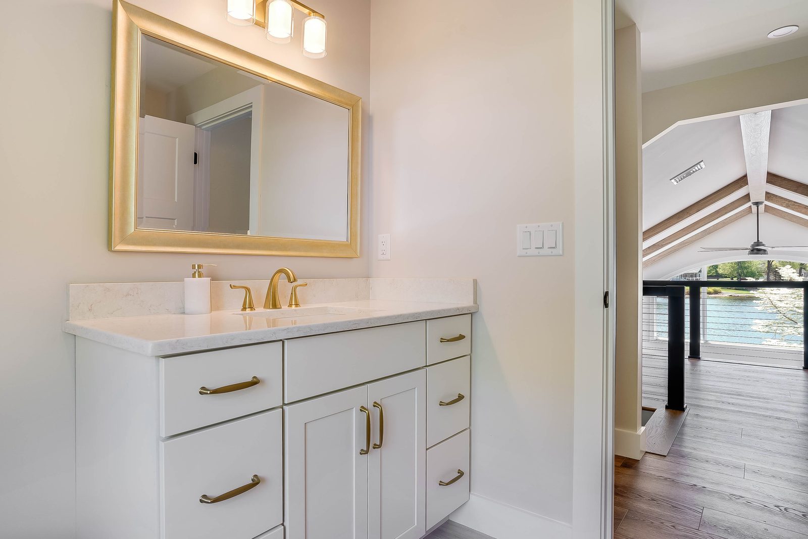 Coconut white vanity with brass hardware and gold mirror