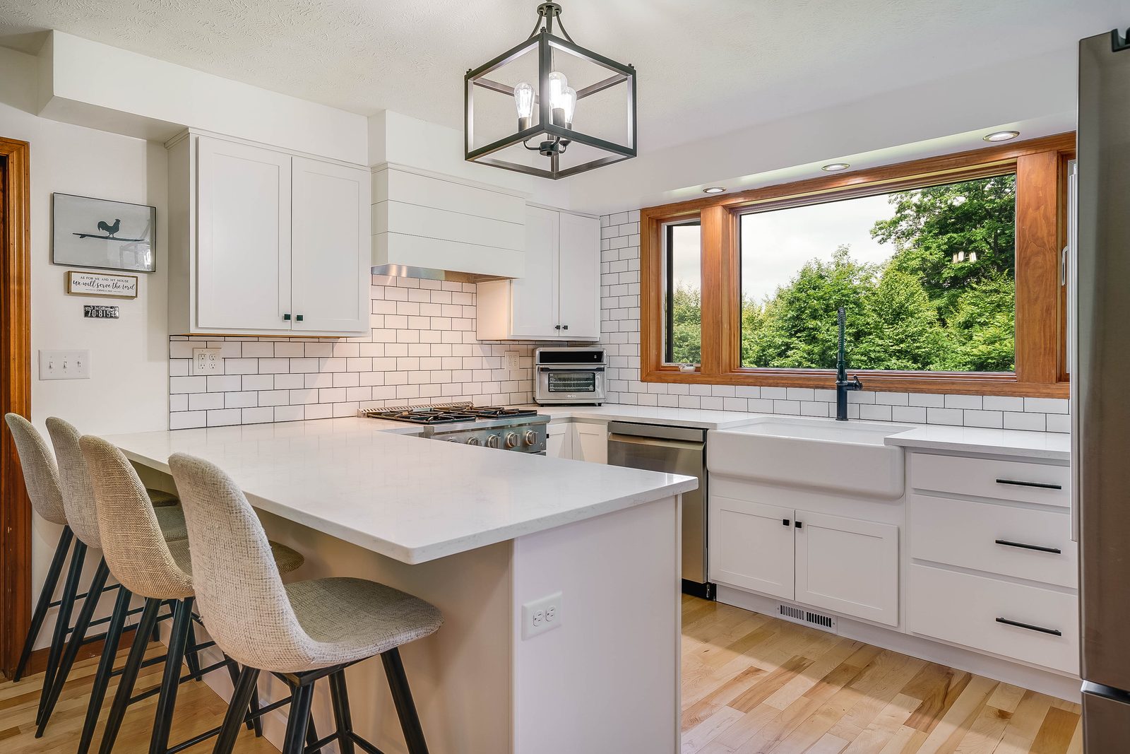 White Westburke kitchen with island seating and maple floors