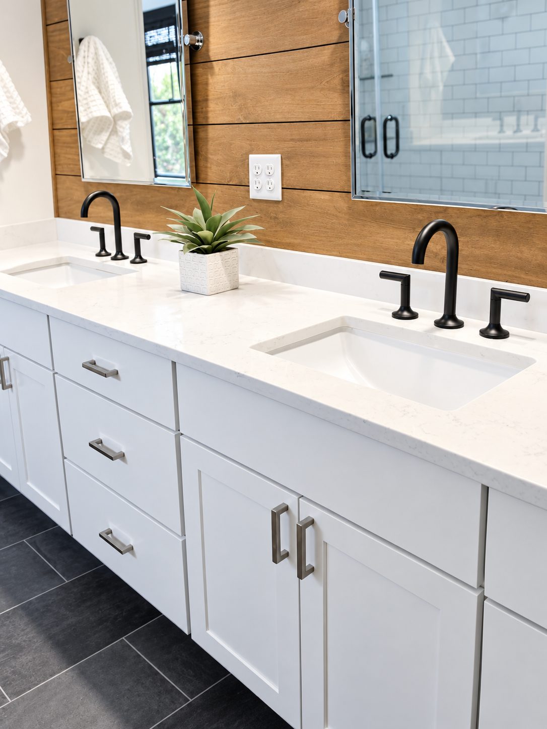 White double vanity with black faucets and shiplap wood accent wall