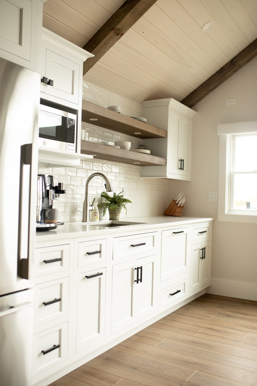 Apartment kitchen with open shelves and timber beam