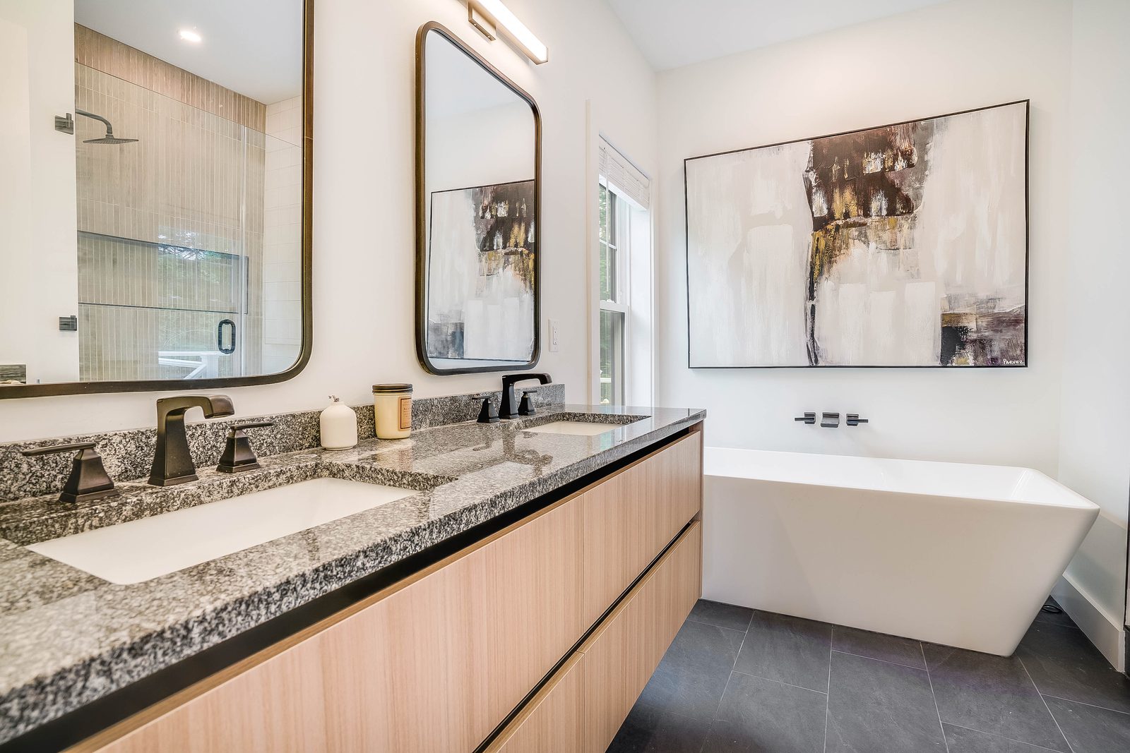 Double slab vanity in Woodline with granite top and freestanding tub