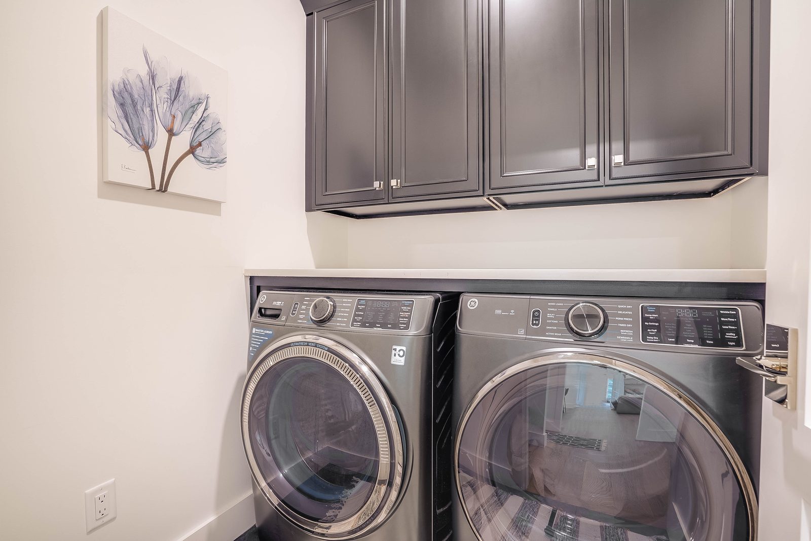 Black laundry cabinets with stacked washer and dryer
