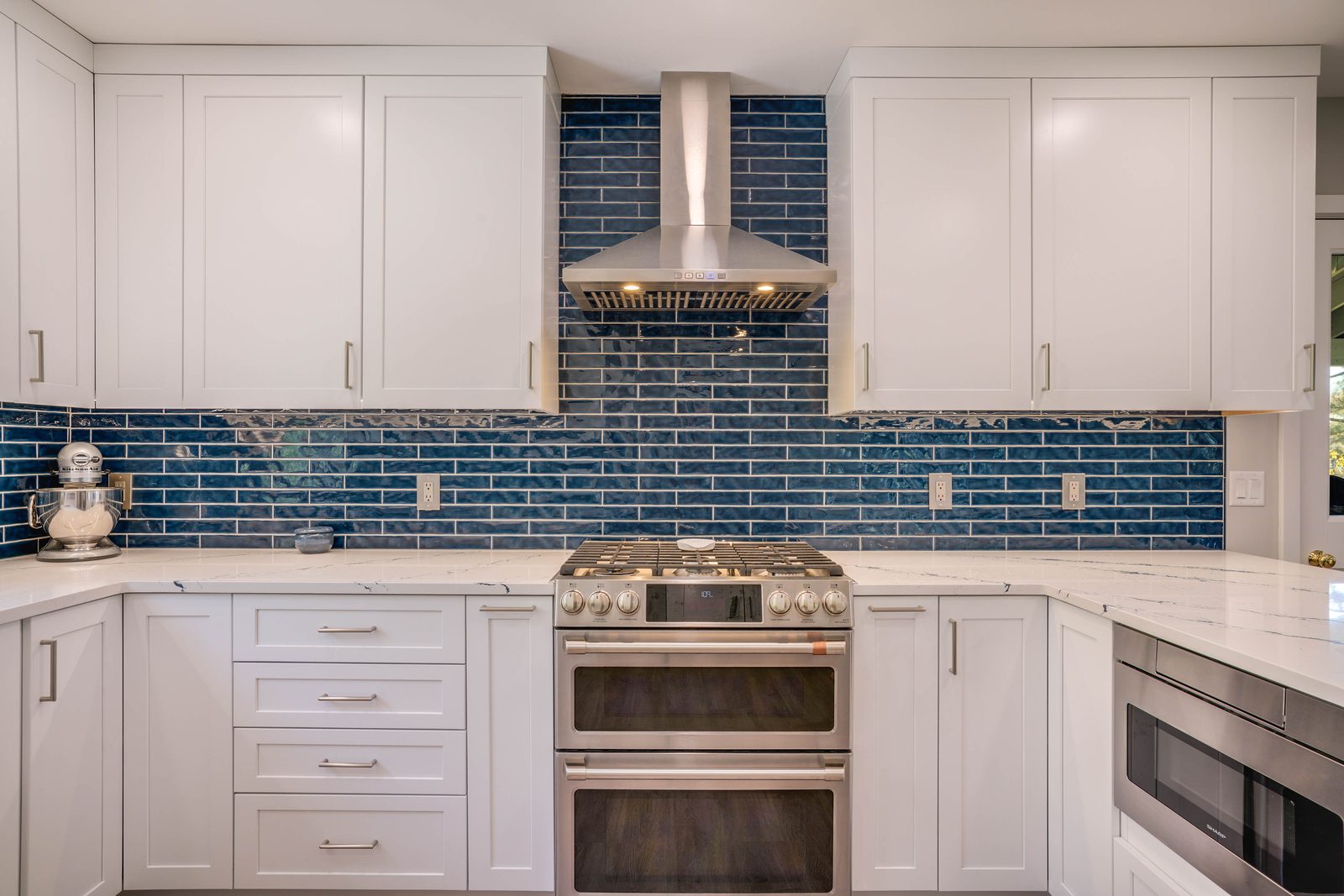 Pro range and hood against blue glass tile