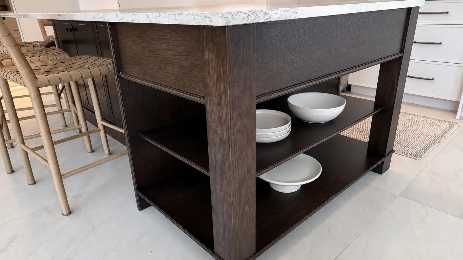 Island end with open shelves holding white serveware