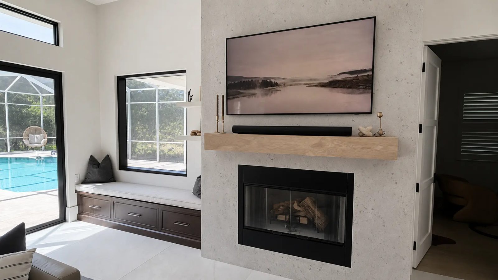 Fireplace wall with white oak mantel and upholstered window-seat bench by the pool doors