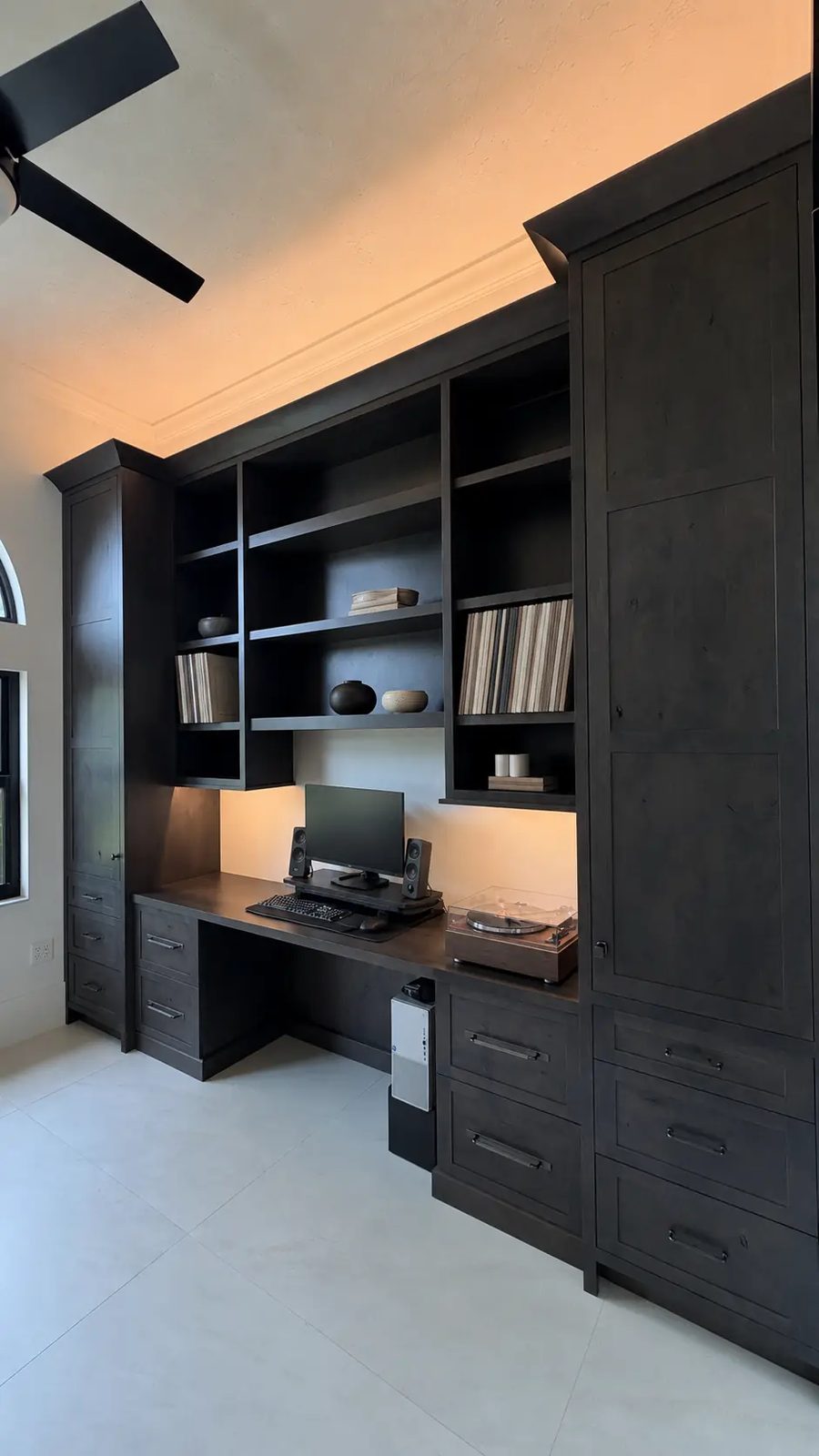 Black-stained office built-in with desk, open shelving and record player