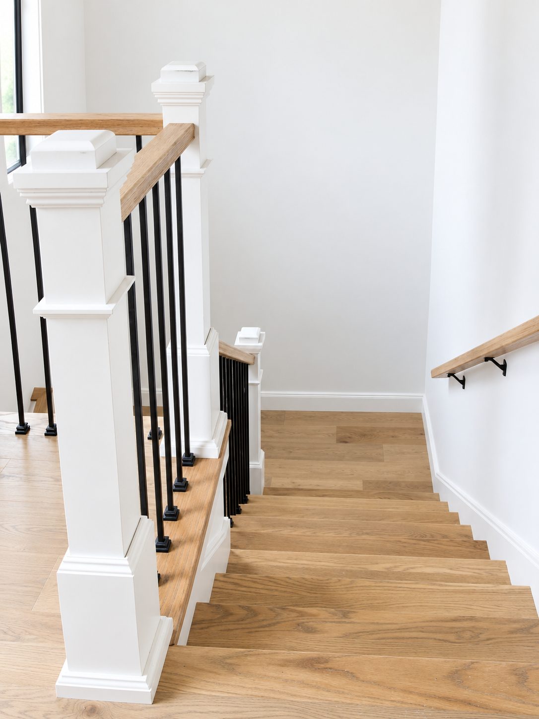 Stair newel post with oak rail and iron balusters