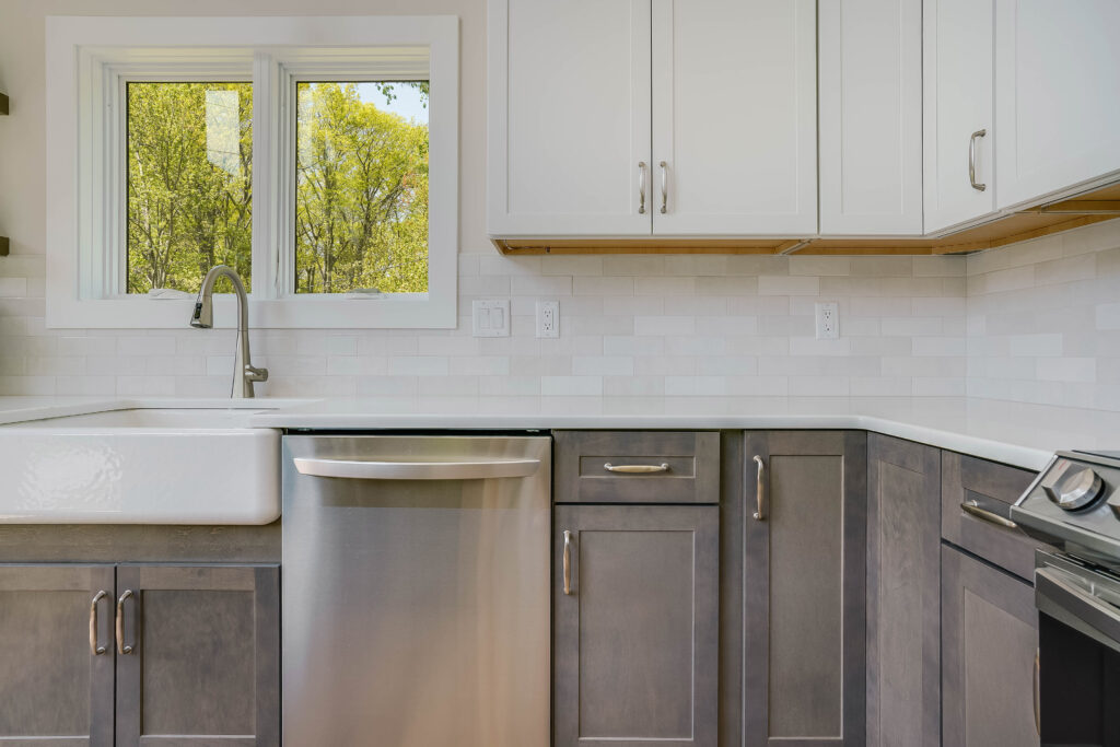 kitchen space with white upper wall cabinets, grey bottom cabinets, and stainless steel appliances
