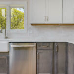 kitchen space with white upper wall cabinets, grey bottom cabinets, and stainless steel appliances