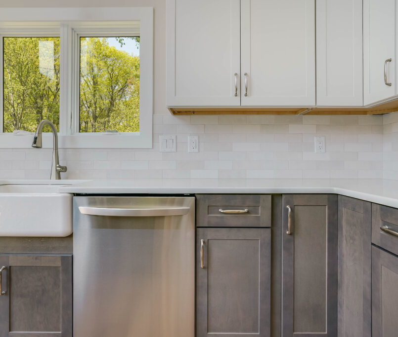 kitchen space with white upper wall cabinets, grey bottom cabinets, and stainless steel appliances