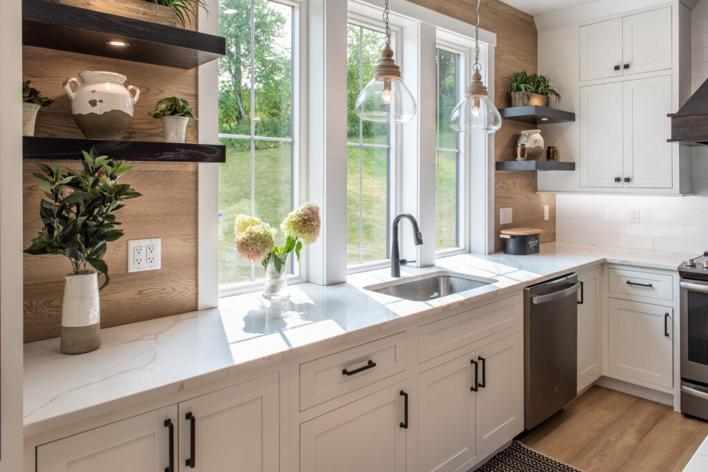 kitchen counter with a window and floating shelves on the wall